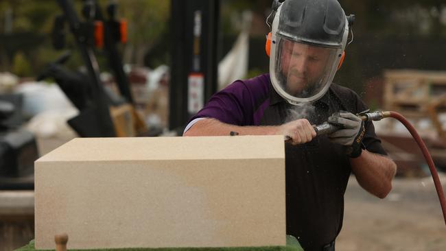 Matthew Johnson works on the stone memorial to Captain James Cook on the grounds of Rookwood Cemetery, where he is employed. Picture: AAP/ Justin Sanson