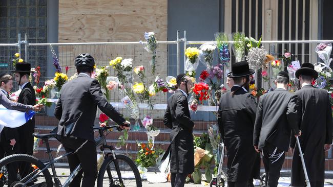 People lay flowers at the Adass Israel Synagogue on Sunday. Picture: David Crosling