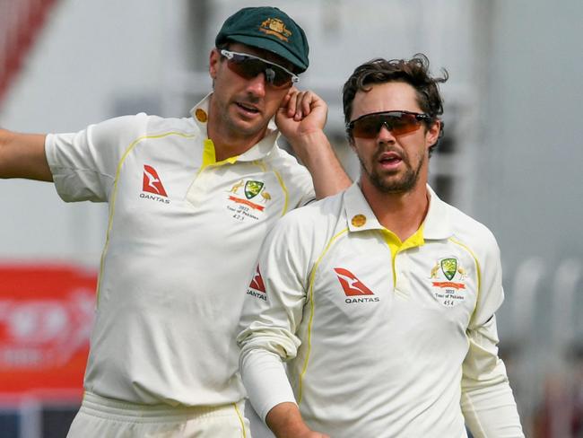 Australia's captain Pat Cummins (L) speaks with bowler Travis Head during the fifth day of the first Test cricket match between Pakistan and Australia at the Rawalpindi Cricket Stadium in Rawalpindi on March 8, 2022. (Photo by Aamir QURESHI / AFP)