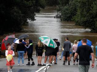 Locals check out the flooded Hawkesbury River at the North Richmond bridge, which is underwater, on Thursday. Picture: Jonathan Ng