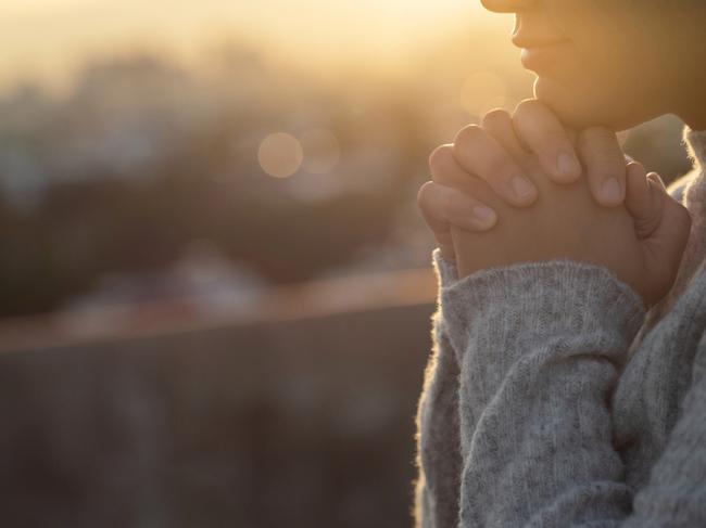 Women raise their hands to ask for blessing from God.