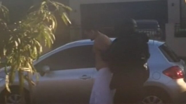 Mahmoud Khayat being led out of a Lakemba property in towel with police. Picture: Nine News Sydney