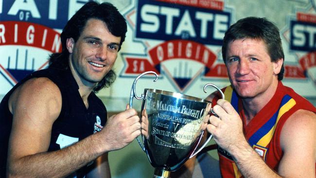 Victorian captain Paul Roos and SA skipper Chris McDermott hold the Malcolm Blight Cup, the prize for the State-of-Origin winner, in July 1992.