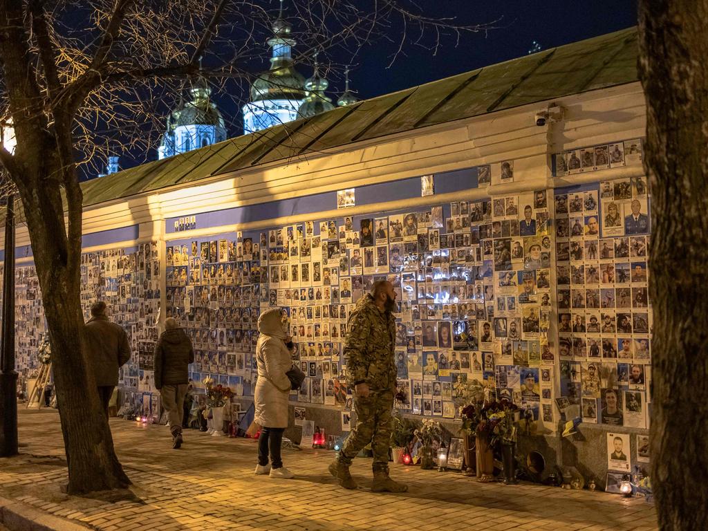 A Ukrainian soldier with others as he visits the "The Wall of Remembrance of the Fallen for Ukraine", a memorial for Ukrainian soldiers, in downtown Kyiv. Picture: Roman Pilipey/AFP