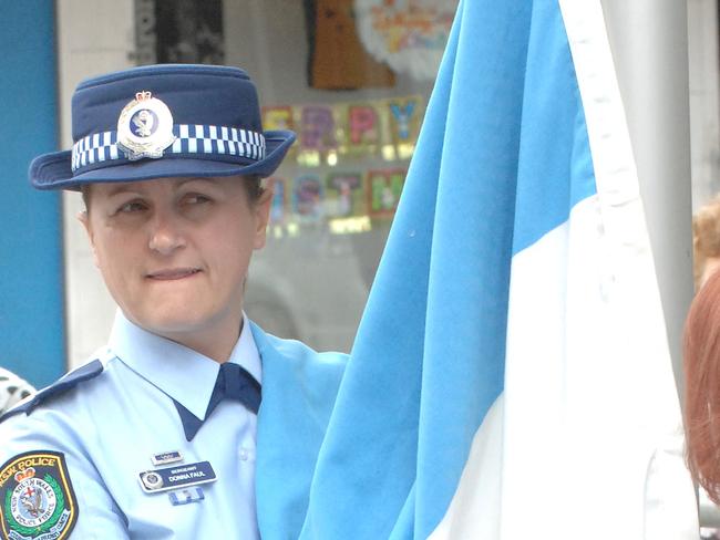 The NSW Police flag, is raised by Sgt Donna Faul, at the official opening of Fairfield police station in Smart St Fairfield.