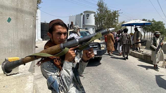 A Taliban fighter stands guard with others at an entrance gate outside the Interior Ministry in Kabul. Picture: AFP