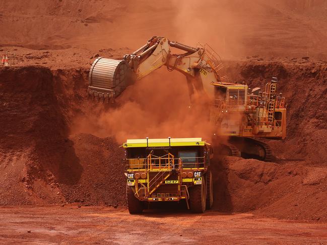 An excavator loads ore into an autonomous dump truck at Fortescue Metals Group Ltd.'s Solomon Hub mining operations in the Pilbara region, Australia, on Thursday, Oct. 27, 2016. Shares in Fortescue, the world's No. 4 iron ore exporter, have almost trebled in 2016 as iron ore recovered, and the company cut costs and repaid debt. Photographer: Brendon Thorne/Bloomberg via Getty Images