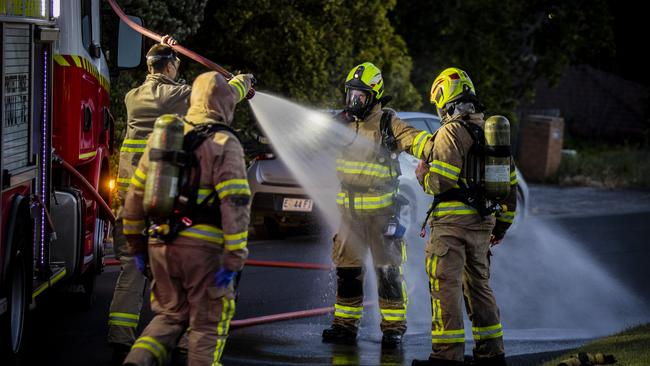 Tasmania Fire Service crews clean off after extinguishing a house fire in Lutana. Picture: RICHARD JUPE