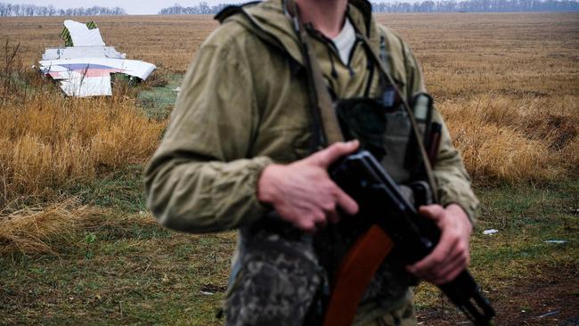 A pro-Russian gunman stands guard next to parts of the Malaysia Airlines Flight MH17 at the crash site. Picture: AFP