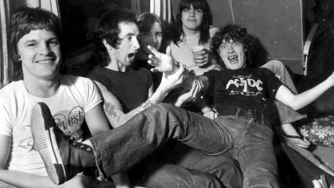 AC/DC on a tour bus in 1976 (L-R) Mark Evans, Bon Scott, Phil Rudd, Malcolm Young &amp; Angus Young. ACDC/Band Scott/singer Picture: Gary Graham