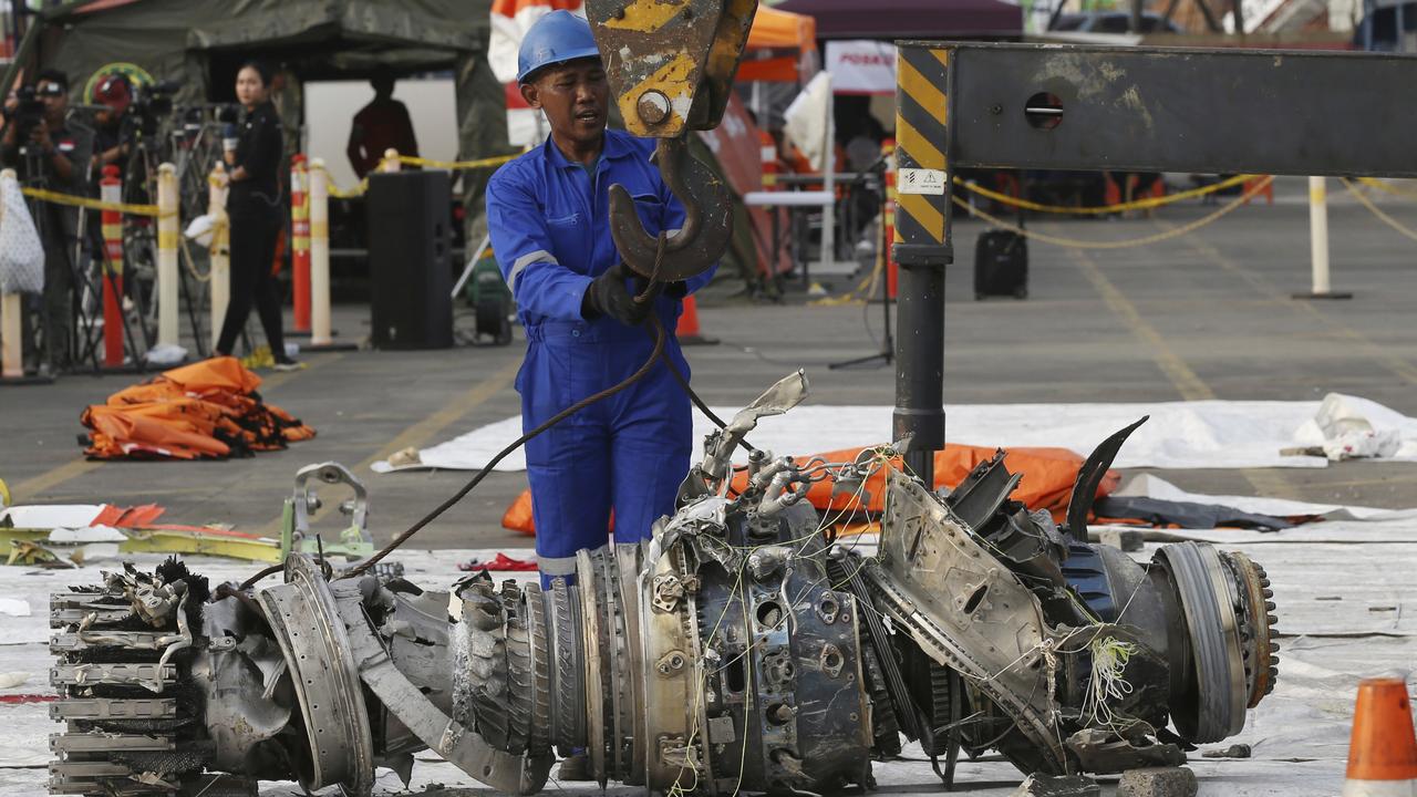 Officials move an engine recovered from the crashed Lion Air jet. Picture: AP/Achmad Ibrahim