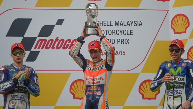 Repsol Honda Team's Spanish rider Dani Pedrosa (C) celebrates with second placed Movistar Yamaha MotoGP's Spanish rider Jorge Lorenzo (L) and third placed Movistar Yamaha MotoGP's Italian rider Valentino Rossi (R) on the podium after winning the Malaysian Grand Prix MotoGP motorcycling race at the Sepang International Circuit on October 25, 2015. AFP PHOTO / MOHD RASFAN