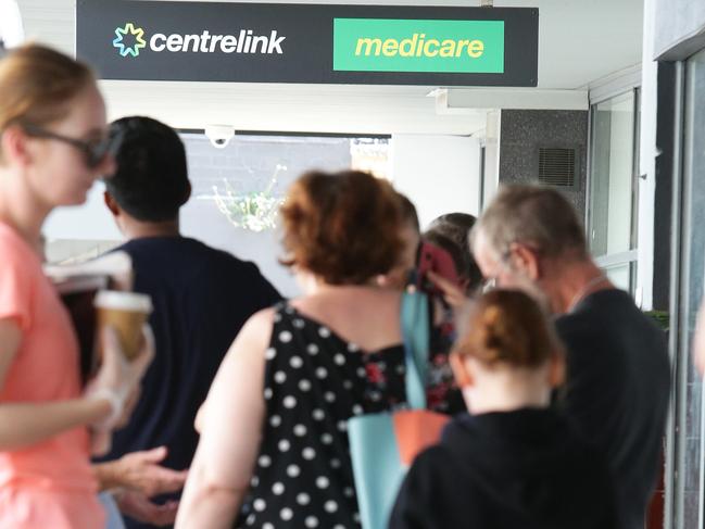 People queue outside Centrelink in Nundah, Brisbane on Thursday, March 26, 2020. Thousands of people seek Centrelink benefits due to mass redundancies since the outbreak of Covid19 virus. (AAP Image/Claudia Baxter)