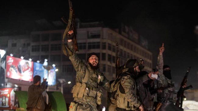 Syrian rebels cheer as they ride a military vehicle through the streets of the west-central city of Hama on Thursday night. Picture: AFP