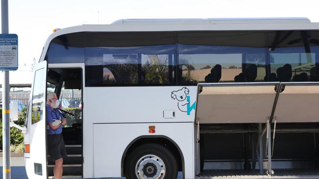 Passengers who arrived on a plane from Melbourne leaving the Gold Coast Airport for quarantine. The bus driver waits for his passengers. Picture: Glenn Hampson.