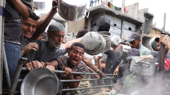 Palestinians struggle to get their food rations outside a crowded distribution centre in Beit Lahia. Picture: AFP