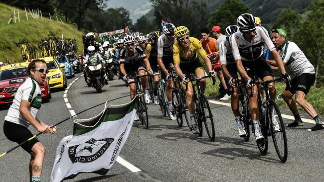 Spectators cheer as Great Britain's Geraint Thomas (C), wearing the overall leader's yellow jersey, Great Britain's Christopher Froome (Behind Thomas) and Netherlands' Tom Dumoulin (L) ride during the 17th stage of the 105th edition of the Tour de France cycling race, between Bagneres-de-Luchon and Saint-Lary-Soulan Col du Portet, southwestern France, on July 25, 2018.  / AFP PHOTO / Marco BERTORELLO