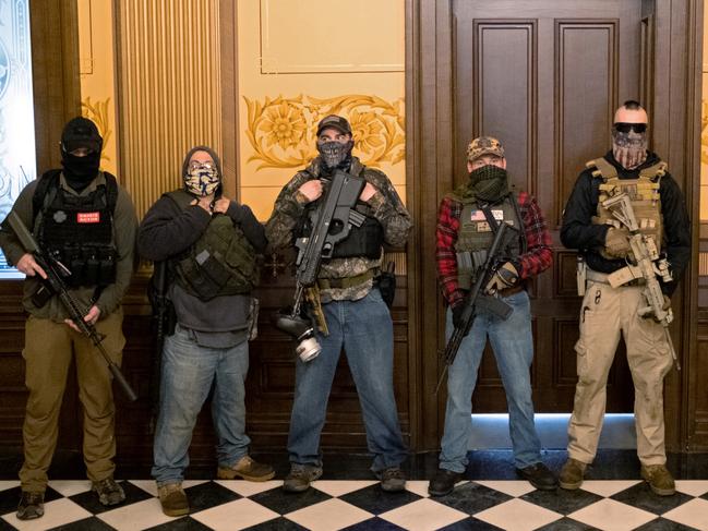 A militia group with no political affiliation from Michigan stands in front of the Governors office after protesters occupied the state capitol building during a vote to approve the extension of Governor Gretchen Whitmer's emergency declaration/stay-at-home order due to the coronavirus disease (COVID-19) outbreak, at the state capitol in Lansing, Michigan, U.S. April 30, 2020.  REUTERS/Seth Herald - RC28FG9SHVHD