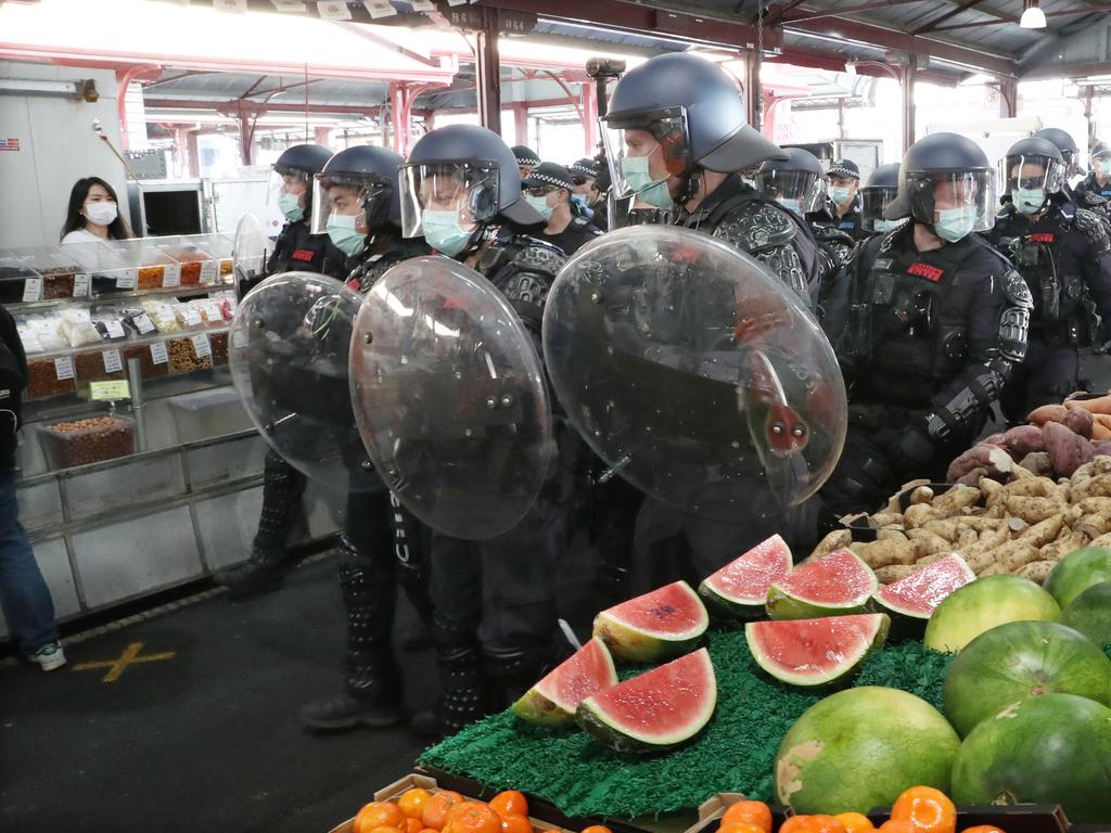 Police march past watermelons at the Queen Victoria Markets. Picture: David Crosling