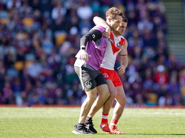 Tom Papleyleaves the field in the hands of a trainer at the Gabba on Sunday. Picture: Russell Freeman/AFL Photos via Getty Images.