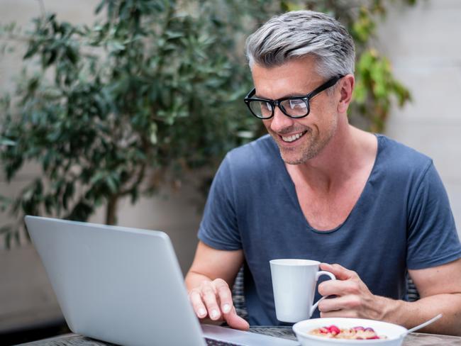 Man working on a laptop at home; Happy investor generic