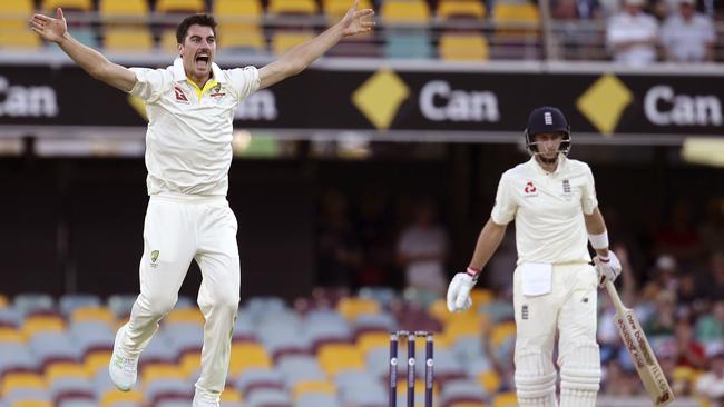 Australian paceman Pat Cummins takes flight after trapping England captain Joe Root during the first day of the first Ashes Test at the Gabba yesterday. Picture: AP