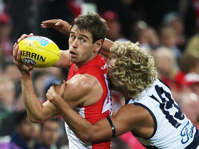 Sydney's Nick Smith handballs ahead of Geelong's Quinton Narkle during AFL match between the Sydney Swans and Geelong Cats at the SCG. Picture. Phil Hillyard