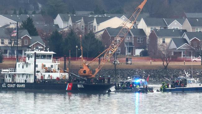 ARLINGTON, VIRGINIA - JANUARY 31: A Coast Guard crane arrives to remove the wreckage of a military Black Hawk helicopter after the crash of an American Airlines plane on the Potomac River as it approached the airport on January 31, 2025 in Arlington, Virginia. The American Airlines flight from Wichita, Kansas collided midair with a military Black Hawk helicopter while on approach to Ronald Reagan Washington National Airport. According to reports, there were no survivors among the 67 people on both aircraft.   Al Drago/Getty Images/AFP (Photo by Al Drago / GETTY IMAGES NORTH AMERICA / Getty Images via AFP)