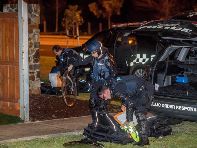 Dozens of police some in riot gear gather near Lonzo Park in Taylors Hill . Police also  blocked off part of Gourlay road. Picture: Jason Edwards