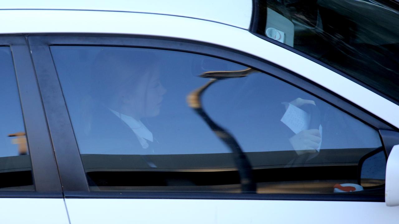 Reading a document in Manly Rd traffic. Picture: John Grainger