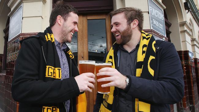 Two Tigers fans show their support at the Swan Hotel. (Photo by Michael Dodge/Getty Images)<br/>                                             <a capiid="6240f17eb6cba6b5885035e236a0bc45" class="capi-video">Calls to move AFL grand final holiday</a>