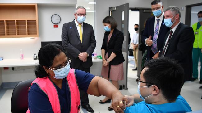 Gladys Berejiklian and Brad Hazzard look on as NSW Health worker Andrew Santos receives his COVID-19 vaccination at the Westmead Hospital vaccination hub. Picture: AAP.