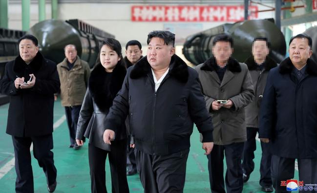 North Korea's leader Kim Jong Un (C) inspects a missile launcher production facility with his daughter Ju Ae (centre L)