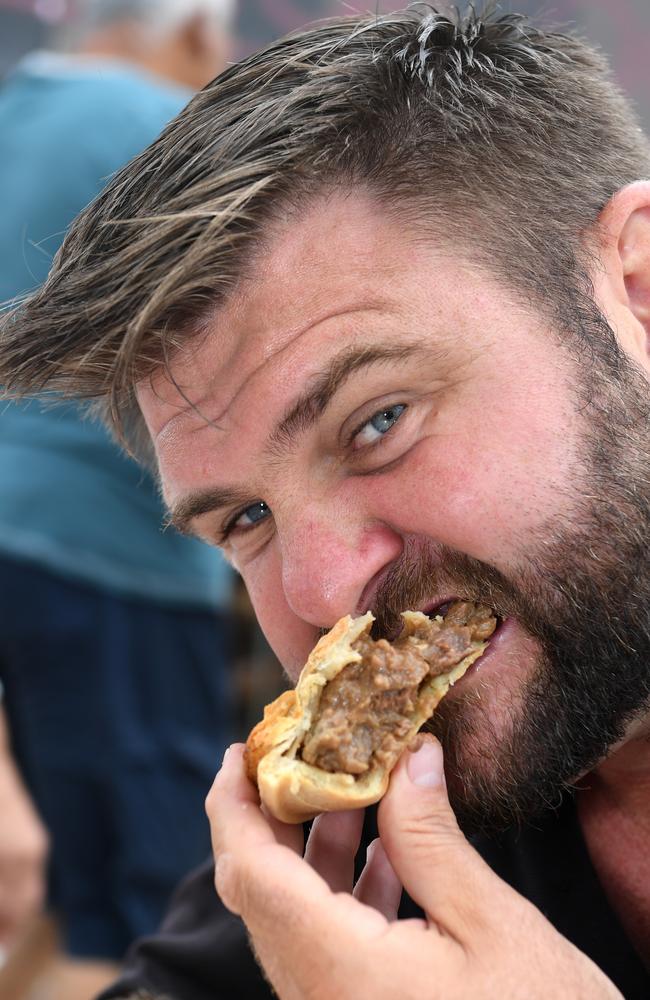 Shaun Pyne tucks into a hearty pie at Marcoola Bakery.