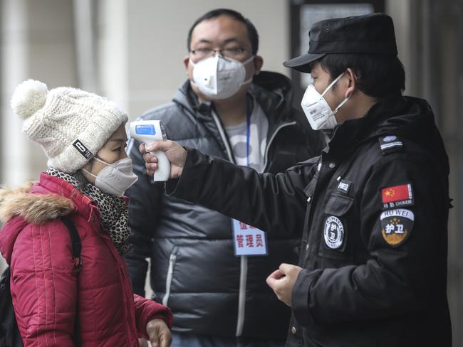 Security personnel check the temperature of passengers in the Wharf at the Yangtze River on January 22, 2020 in Wuhan. Picture: Getty Images