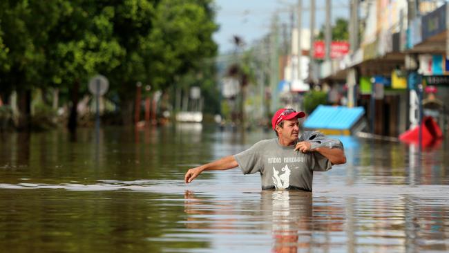 A resident wades through waters on Keen St in the CBD of Lismore. Picture: Nathan Edwards