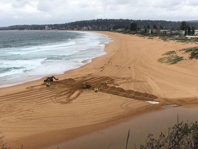 Northern Beaches Council workers at North Narrabeen Beach preparing a channel to open Narrabeen Lagoon to the ocean