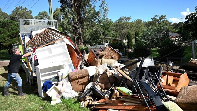 A man piles up damaged possessions outside his house in Londonderry in Sydney’s West. Picture: Saeed Khan