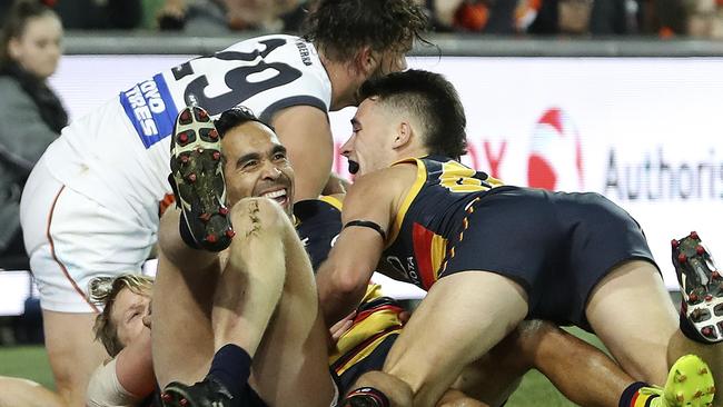 Lachlan Murphy and Rory Sloane jump on Eddie Betts after his stunning last-quarter goal. Picture: Sarah Reed