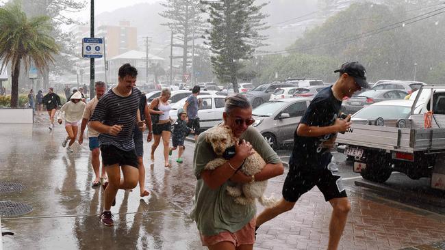 Members of the public run for shelter during a torrential downpour in Burleigh on the Gold Coast ahead of the expected arrival of Cyclone Alfred. Picture: NewsWire/Tertius Pickard