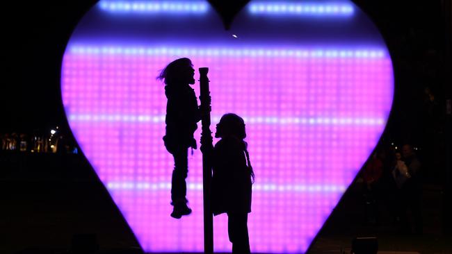 Young children shout “I love you” at the I Love You installation at First Fleet Park as part of the Vivid Sydney Festival of light. Picture: Dean Lewins/AAP