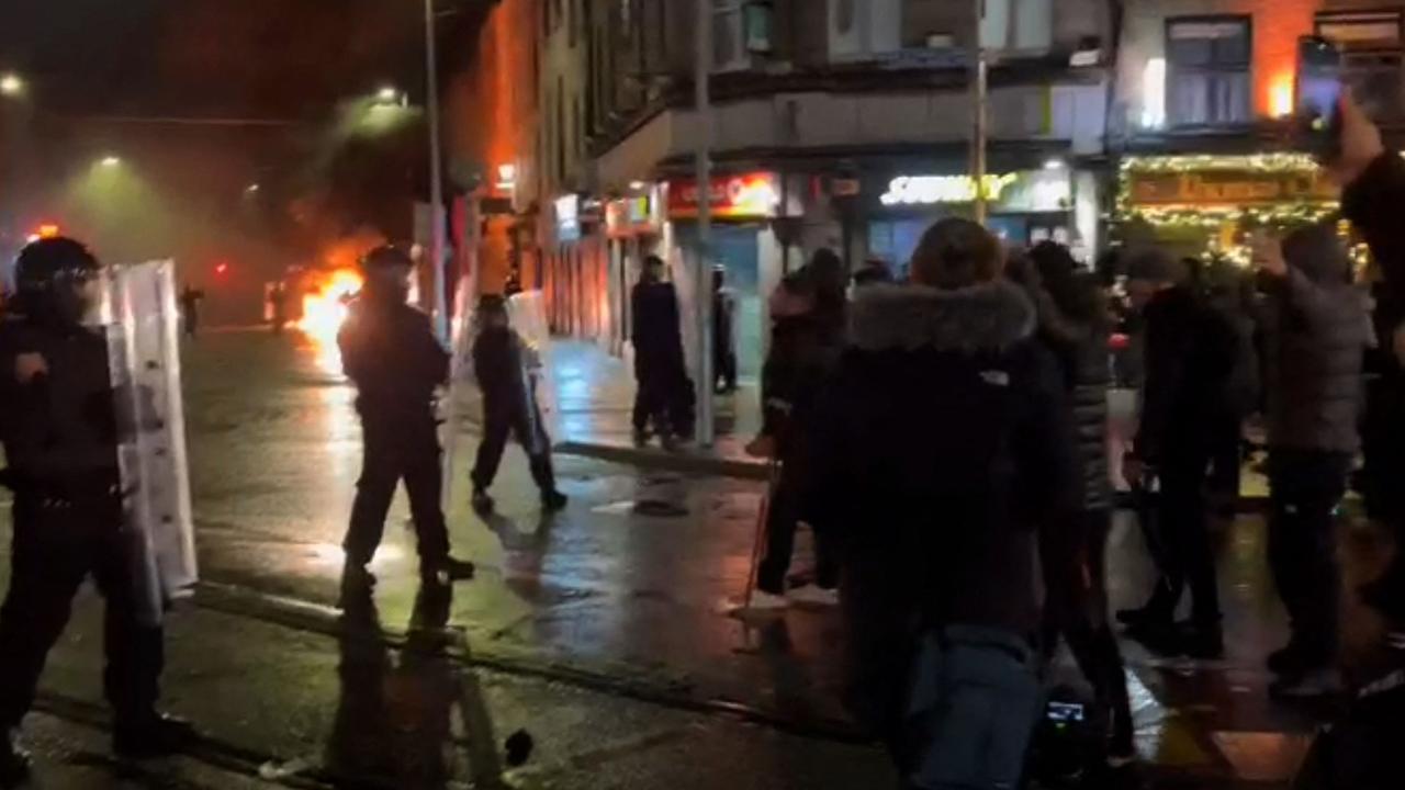 Irish Garda riot police forming a cordon around a burning police car, on Parnell Street in Dublin. Picture: AFP