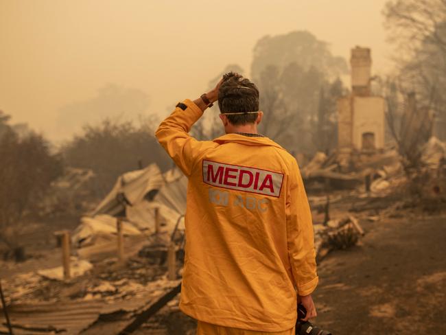 ABC photographer Matt Roberts reacts to seeing his sister's destroyed house in Quaama, NSW. Picture: AAP