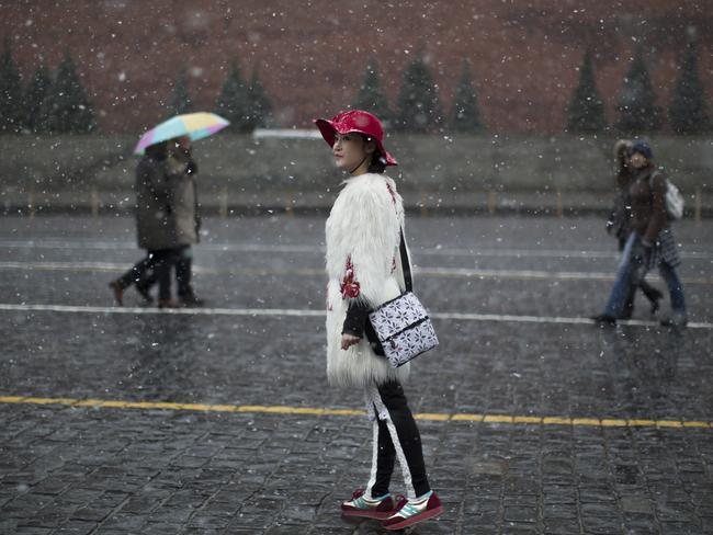 A Chinese tourist poses for a photo at the Red Square in Moscow. AP Photo/Alexander Zemlianichenko