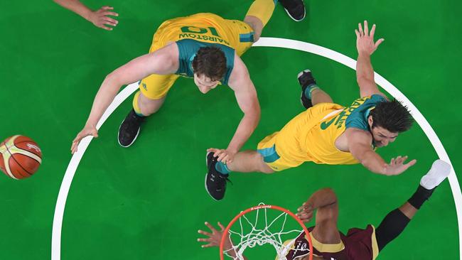 An overview shows Venezuela's point guard Gregory Vargas (Bottom), Australia's guard Damian Martin (R) and Australia's forward Cameron Bairstow go for a rebound during a Men's round Group A basketball match between Australia and Venezuela at the Carioca Arena 1 in Rio de Janeiro on August 14, 2016 during the Rio 2016 Olympic Games. / AFP PHOTO / Andrej ISAKOVIC