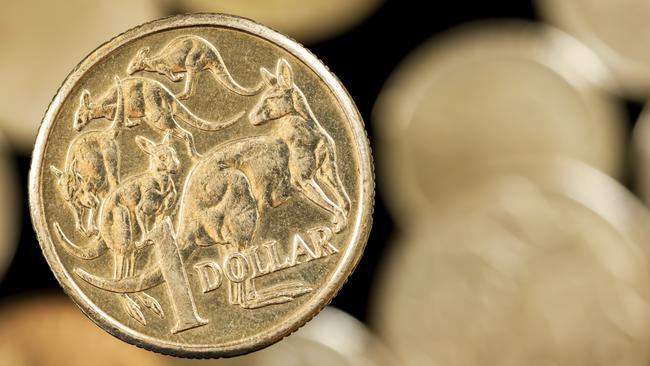 Australian one dollar coin over blurred golden background.