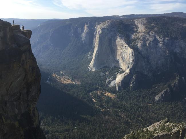 FILE - In this Sept. 27, 2018 file photo a wedding couple are seen being photographed at Taft Point in California's Yosemite National Park. A Yosemite National Park official says two visitors have died in a fall from the popular overlook. Park rangers are trying to recover the bodies of a man and a woman Thursday, Oct.25, 2018. He didn't say when the couple fell from Taft Point, which is at an elevation of 7,500 feet. Gediman says the deaths are being investigated and offered no other information. (AP Photo/Amanda Lee Myers,File)