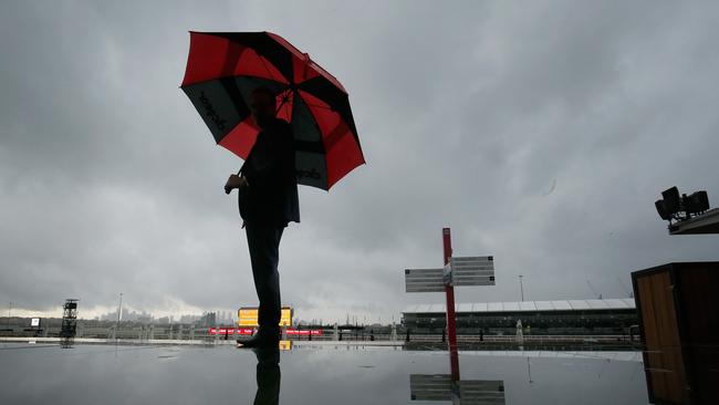 A racing fan arrives early for Melbourne Cup Day at a damp Flemington racecourse. Photo: Getty Images