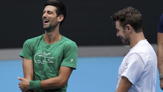 Serbia's Novak Djokovic talks with Switzerland's Stan Wawrinka during a practice session ahead of the Australian Open. Picture: Lee Jin-man/AP