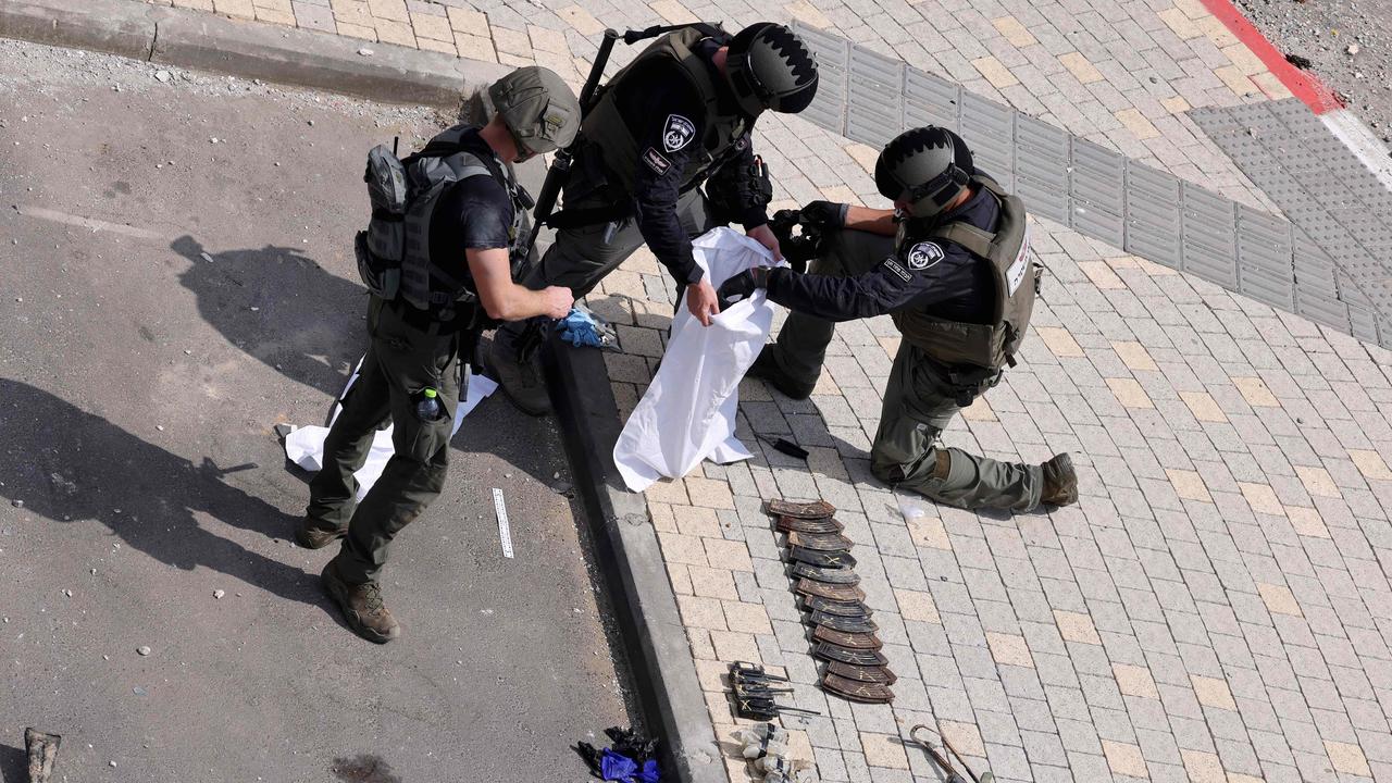 Israeli soldiers inspect the weapons used by Palestinian fighters in front of an Israeli police station in Sderot, Israel on October 8, 2023. Picture: JACK GUEZ / AFP